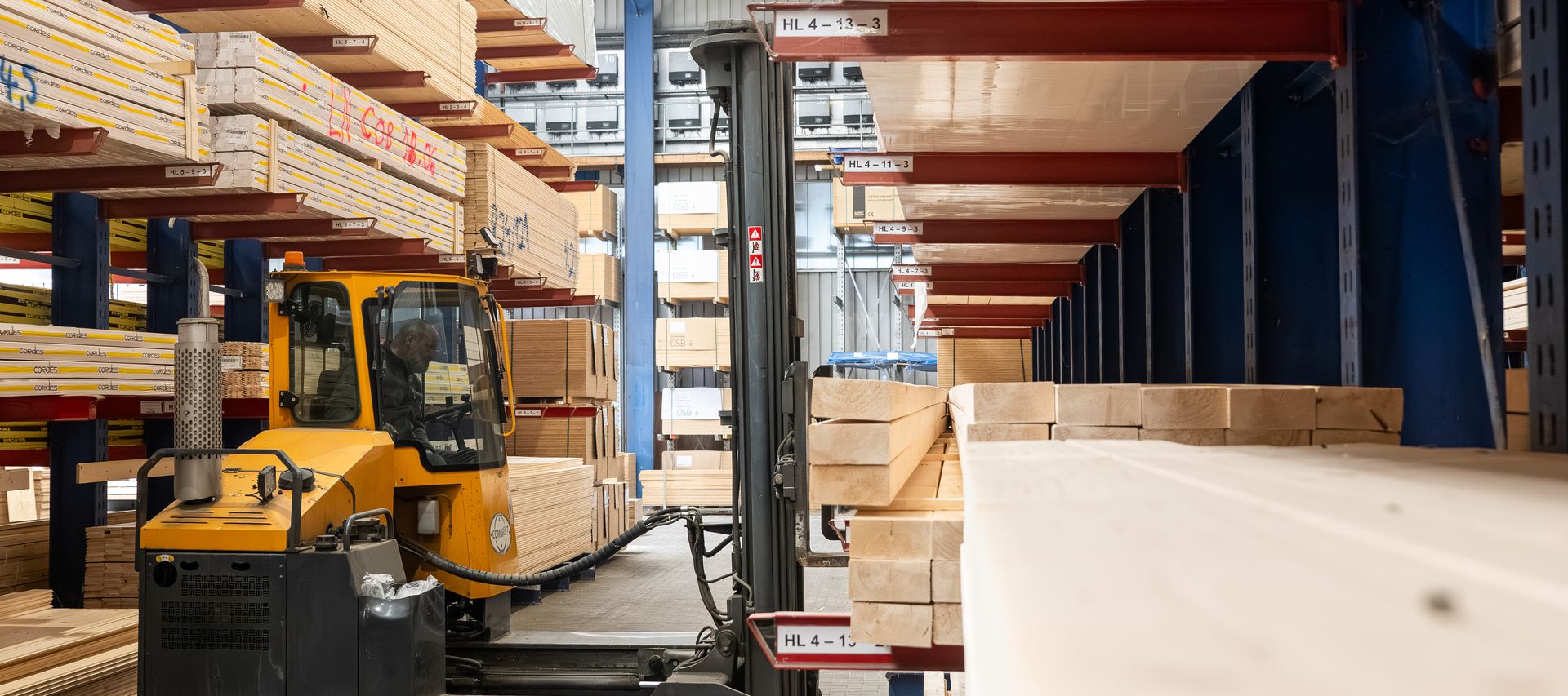 Seitenstapler im Holzlager beim Einlagern von Bauholz und Plattenmaterial