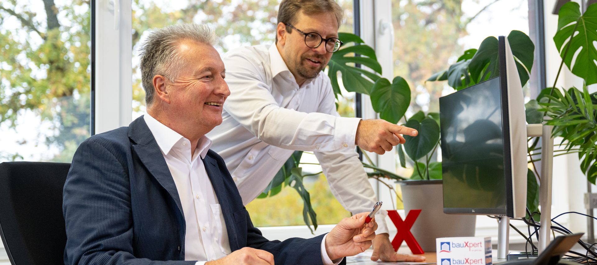 Mitarbeiter der bauXpert Zentrale im Bereich Xpert Direkt bei digitaler Abstimmung am Arbeitsplatz