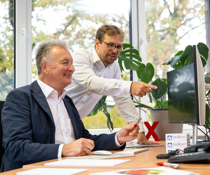 Mitarbeiter der bauXpert Zentrale im Bereich Xpert Direkt bei digitaler Abstimmung am Arbeitsplatz