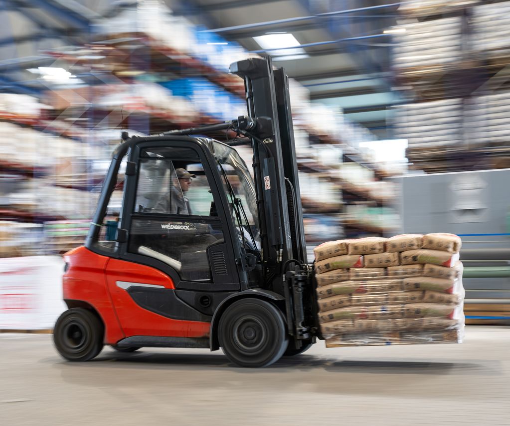 Gabelstapler transportiert palettierte Sackware durch das Lager im Baustoffhandel