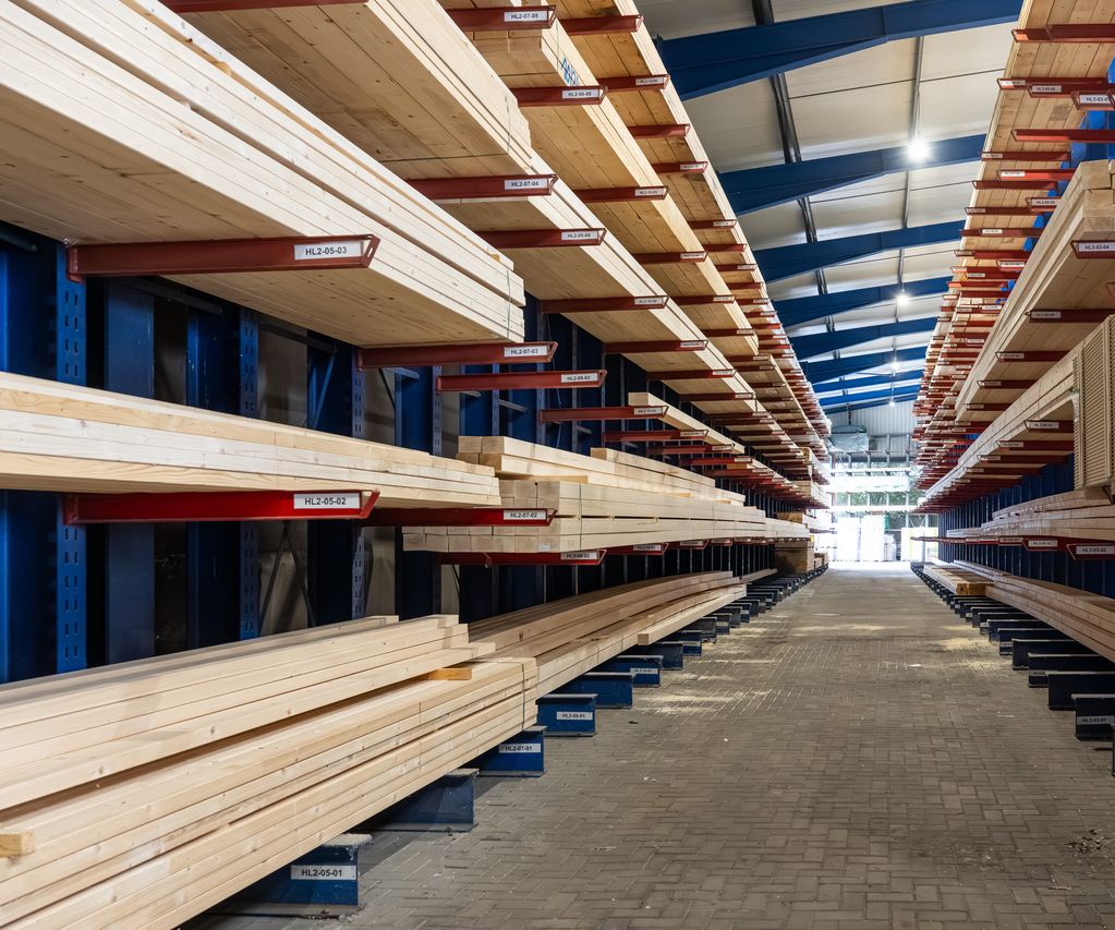 Holzlager mit Bauholz und Leimholzplatten in Regalen im Baustoffhandel