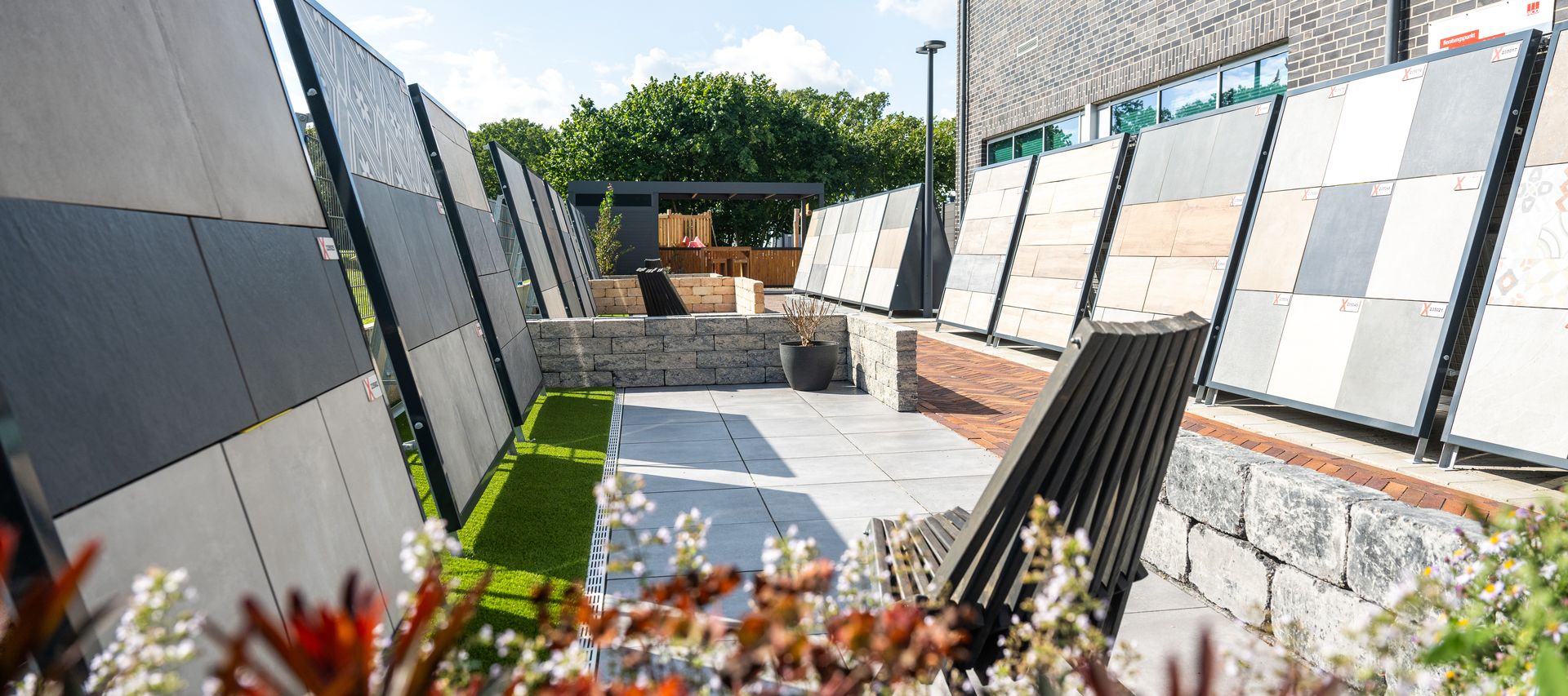 Ausstellung mit Terrassenplatten und Musterwänden im Außenbereich des Baustoffhandels