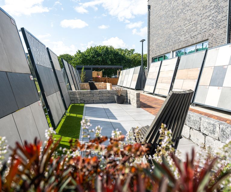 Ausstellung mit Terrassenplatten und Musterwänden im Außenbereich des Baustoffhandels
