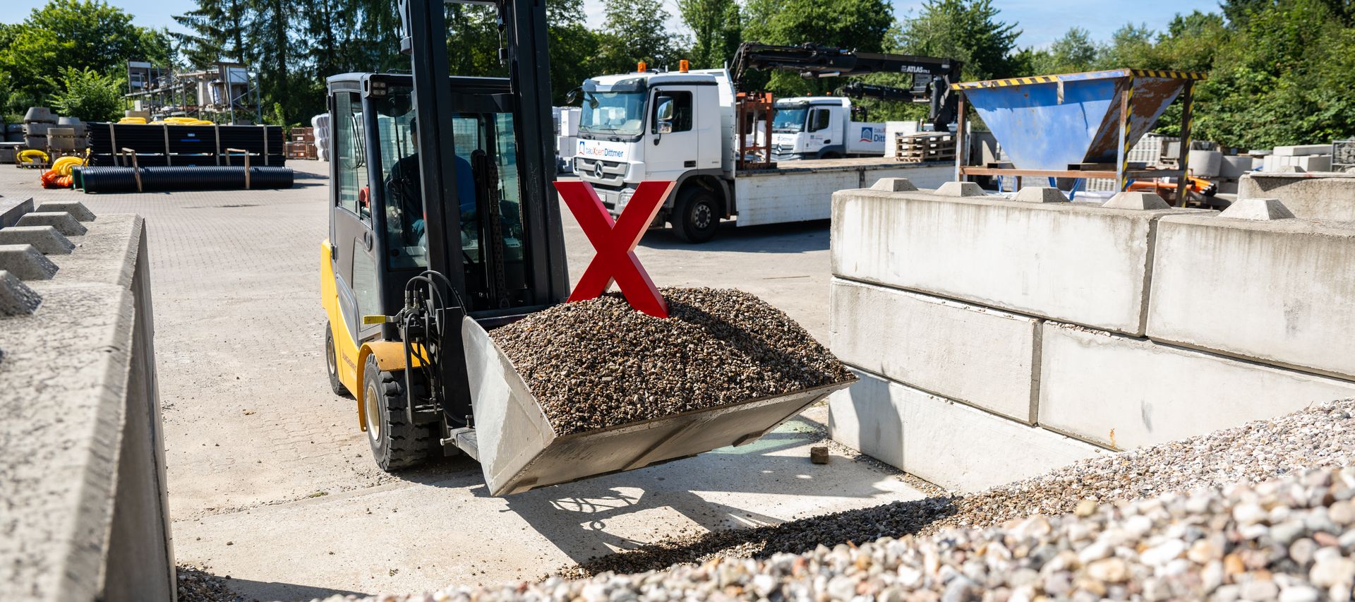 Radlader im Baustoffhandel transportiert Schüttgut im Außenlager