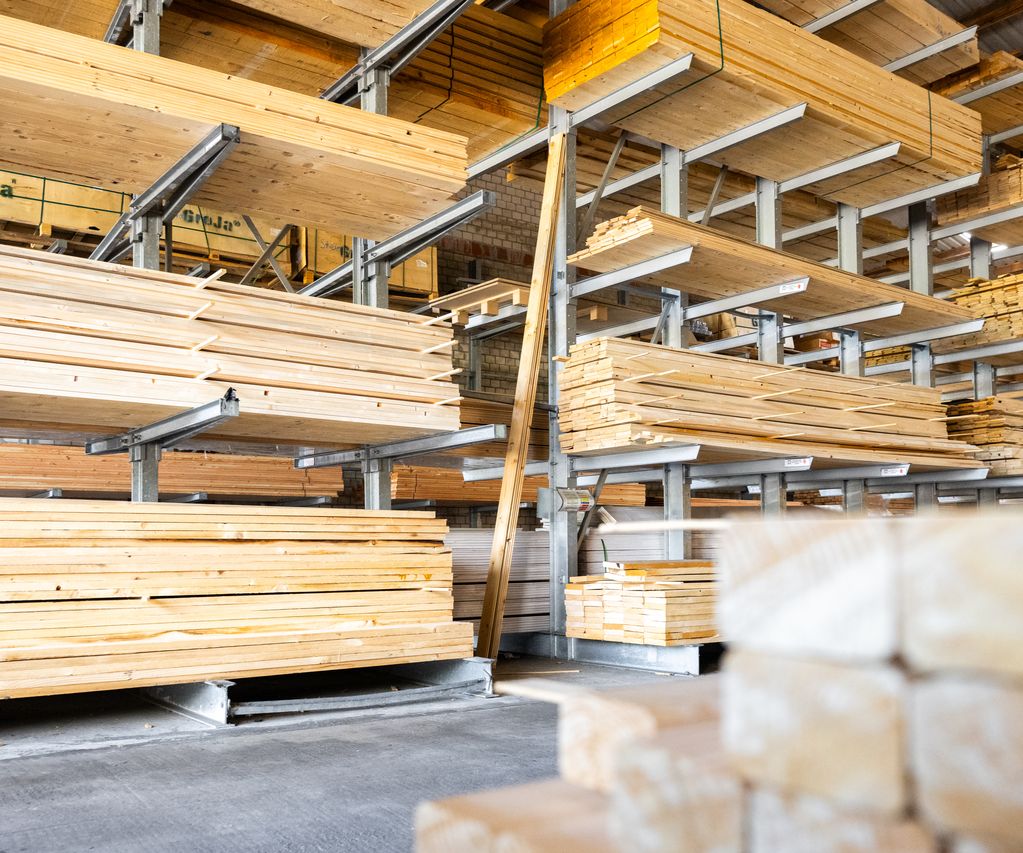 Holzlager mit Konstruktionsholz und Brettern im Regal im Baustoffhandel