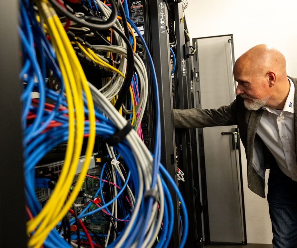 IT-Mitarbeiter der bauXpert Zentrale im Serverraum bei Wartung der Systeminfrastruktur
