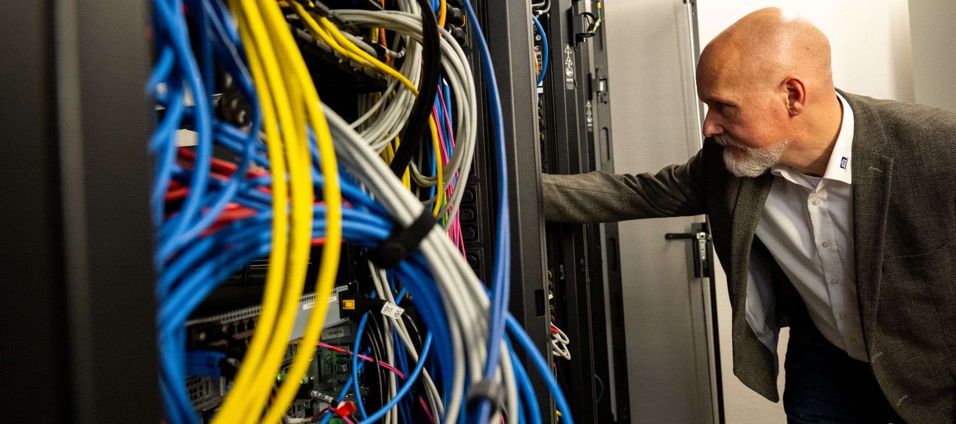 IT-Mitarbeiter der bauXpert Zentrale im Serverraum bei Wartung der Systeminfrastruktur