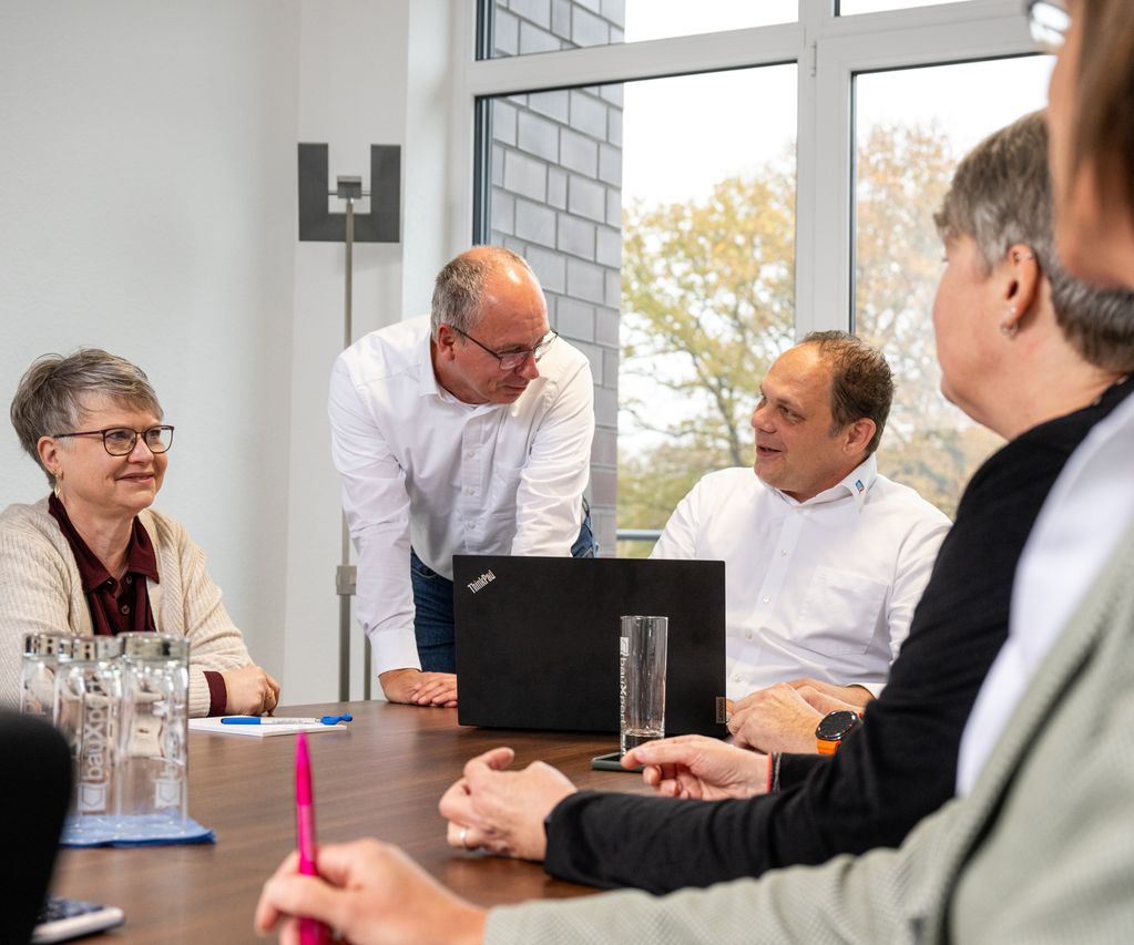 Team Buchhaltung der bauXpert Zentrale im Austausch während einer Besprechung