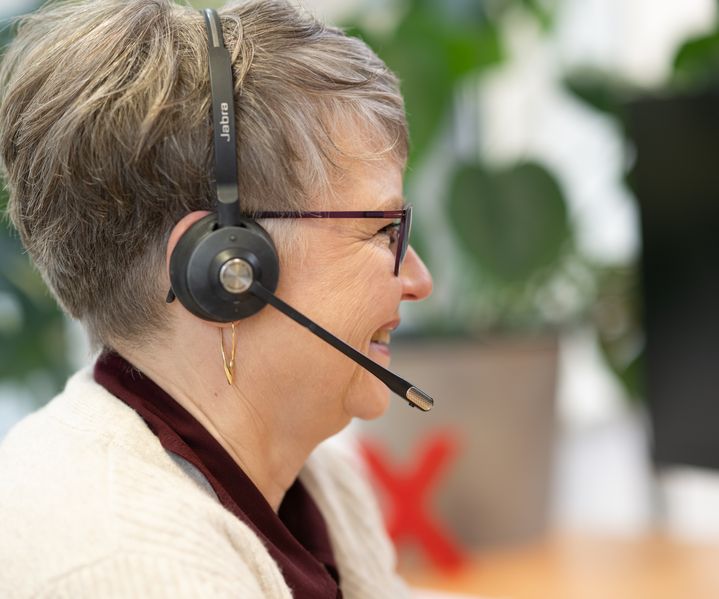 Mitarbeiterin der bauXpert Zentrale mit Headset im Kundengespräch oder interner Abstimmung