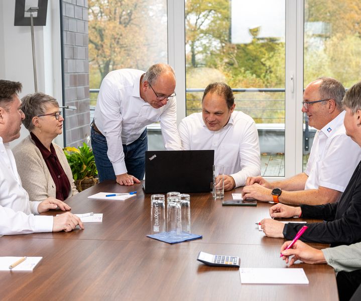 Teammeeting der Abteilung Buchhaltung bei bauXpert Zentrale mit Laptop für interne Strategiebesprechung