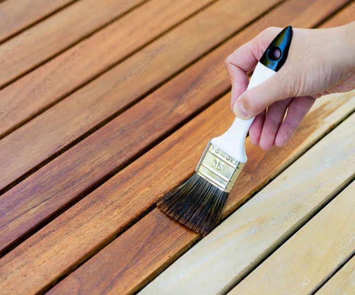 Holzlasur wird auf eine Holzoberfläche aufgetragen und schützt das Material vor Witterungseinflüssen.
