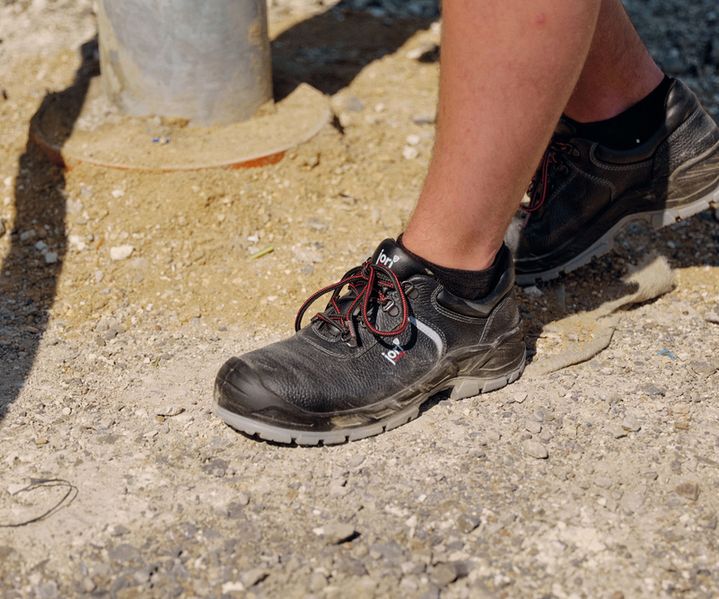 Robuste Arbeitsschuhe mit verstärkter Schutzkappe stehen bereit für den Einsatz auf der Baustelle.