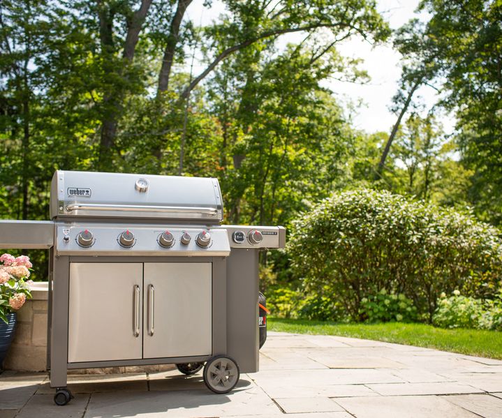 Ein Gasgrill mit mehreren Brennern steht auf der Terrasse und ist einsatzbereit.