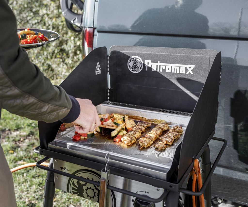 Auf einer heißen Plancha werden verschiedene Speisen gleichmäßig gegart.