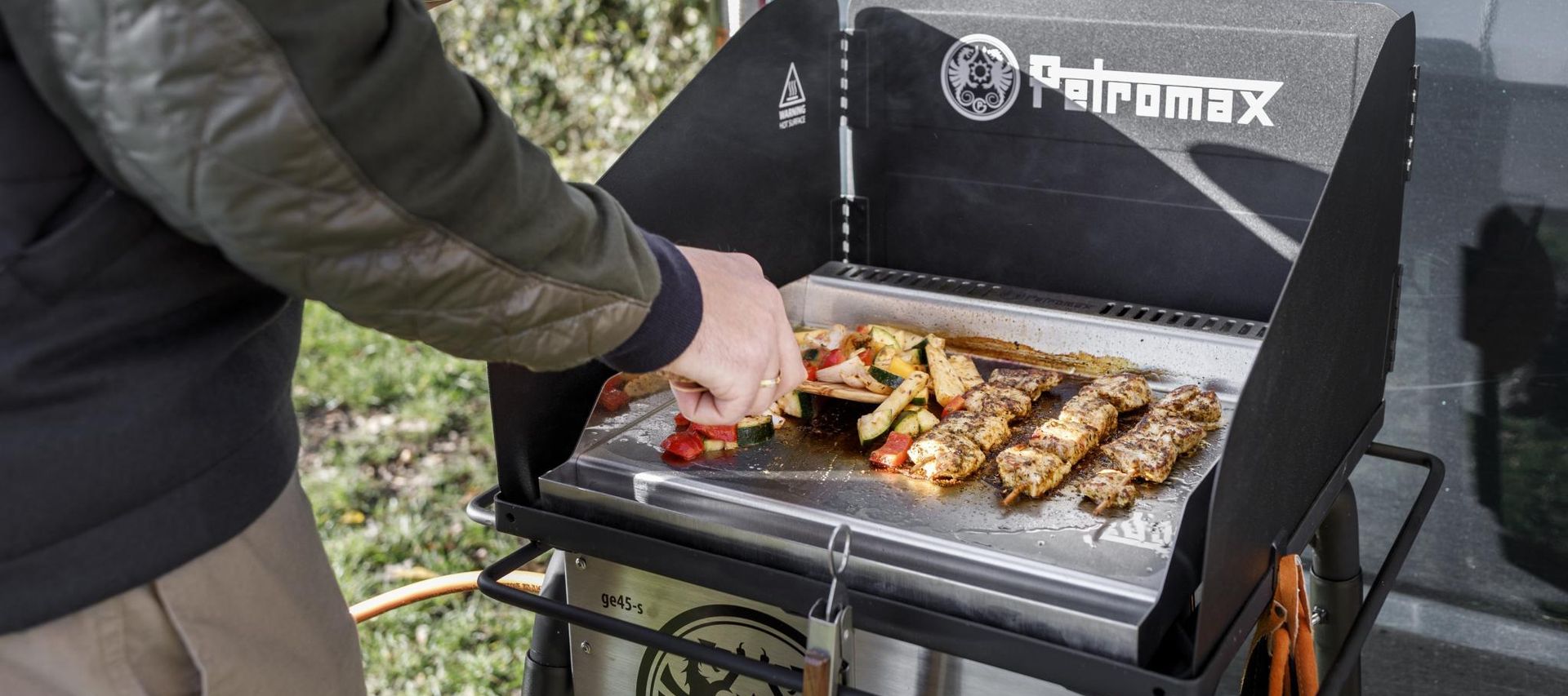 Auf einer heißen Plancha werden verschiedene Speisen gleichmäßig gegart.