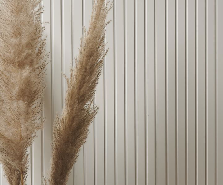 Moderne Wandpaneele sind gleichmäßig an der Wand montiert und verleihen dem Raum eine strukturierte Optik.