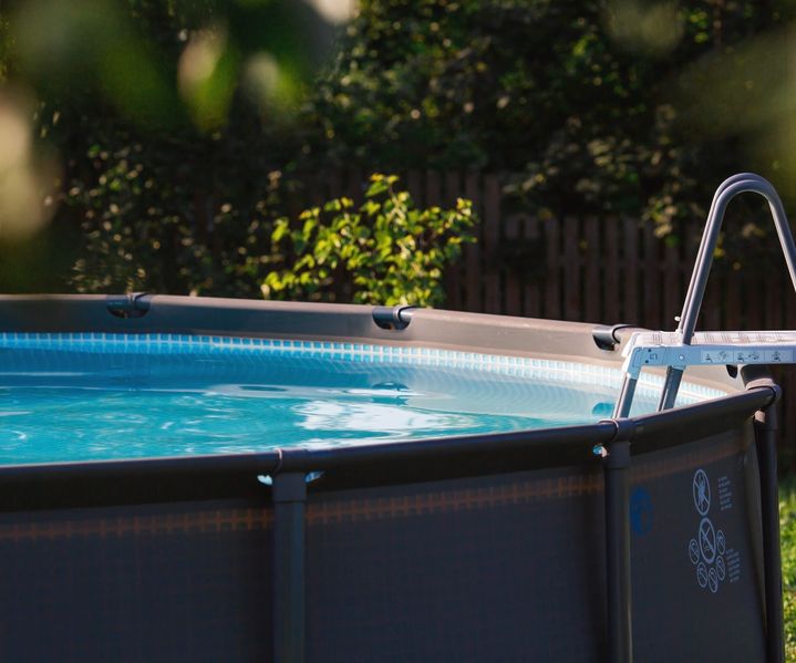 Ein Aufstellpool steht auf der Terrasse und bietet Abkühlung im eigenen Außenbereich.
