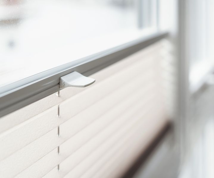 Ein Rollo ist am Fenster montiert und schützt den Raum vor direkter Sonneneinstrahlung.