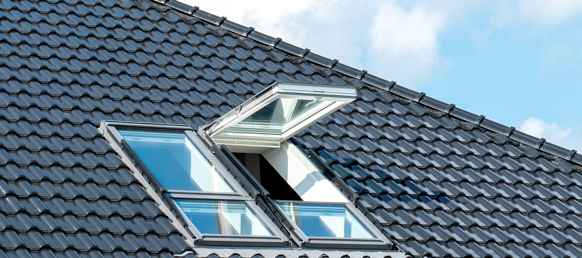 Ein Dachfenster ist in eine geneigte Dachfläche eingebaut und lässt Tageslicht in den Dachraum