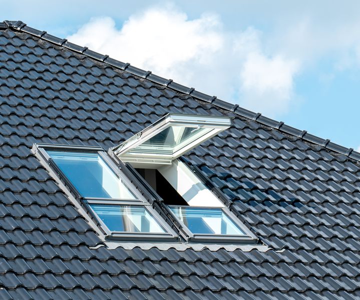 Ein Dachfenster ist in eine geneigte Dachfläche eingebaut und lässt Tageslicht in den Dachraum