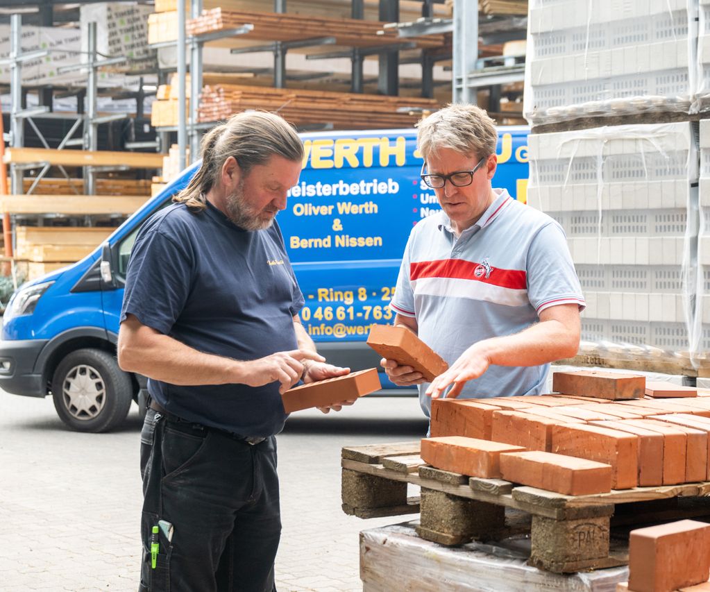 Paletten mit Pflasterklinkern und Steinen sind im Außenlager übersichtlich gestapelt.
