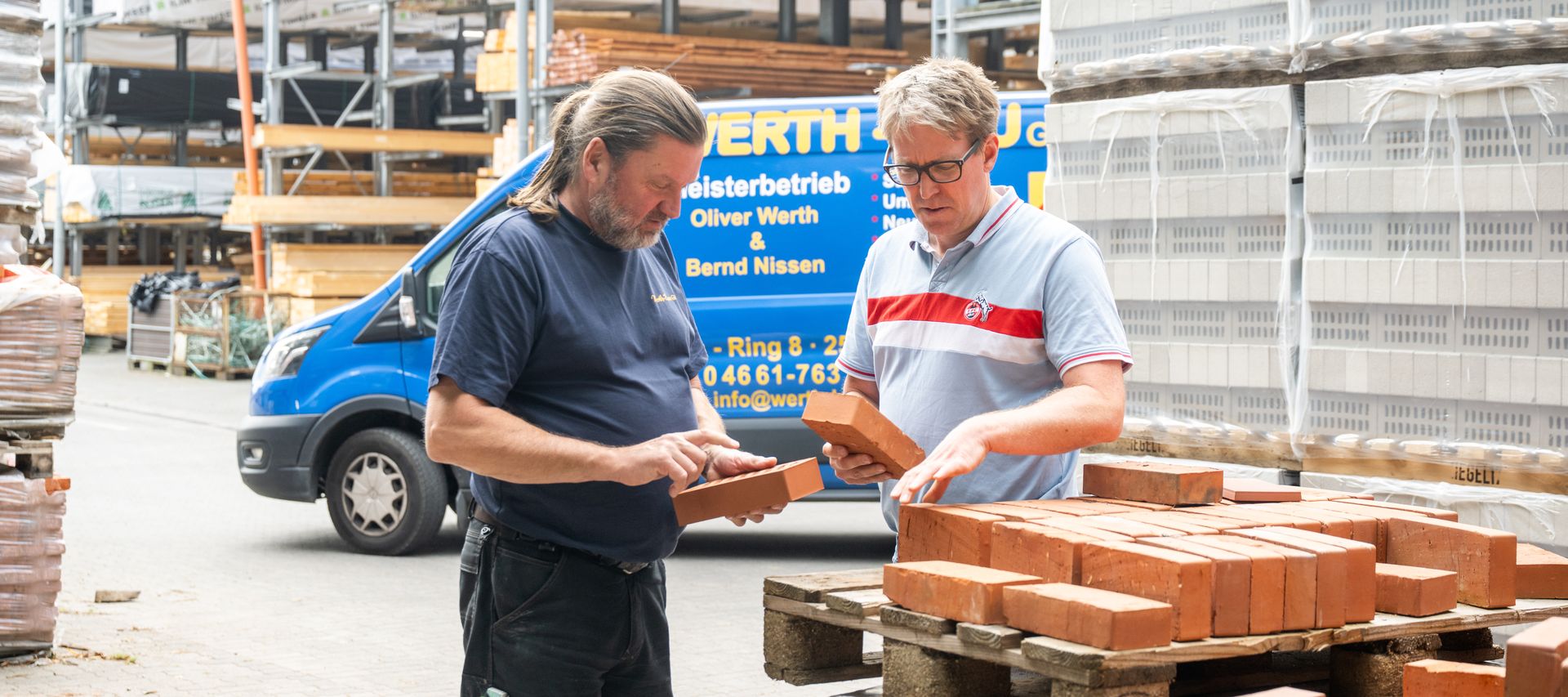 Paletten mit Pflasterklinkern und Steinen sind im Außenlager übersichtlich gestapelt.