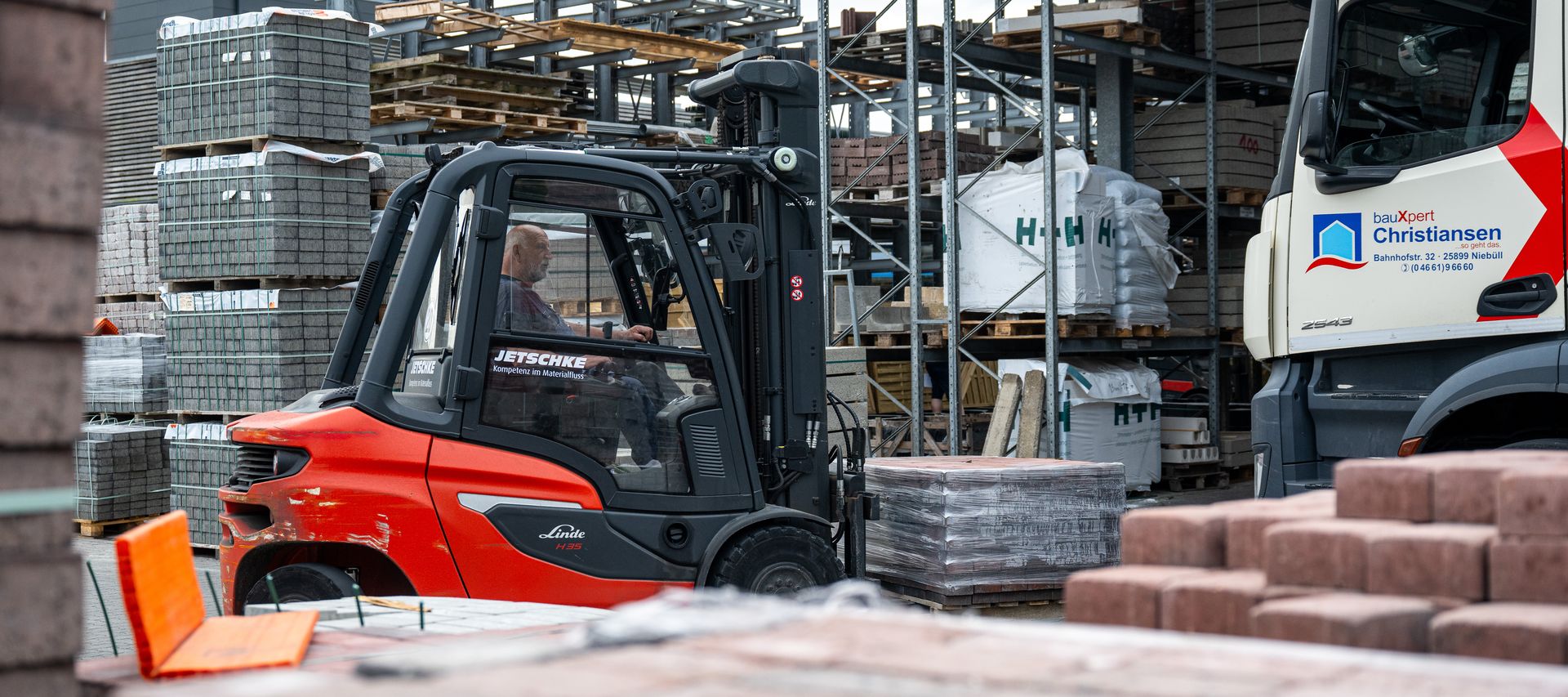 Ein Gabelstapler transportiert Paletten mit Baustoffen über das Betriebsgelände.