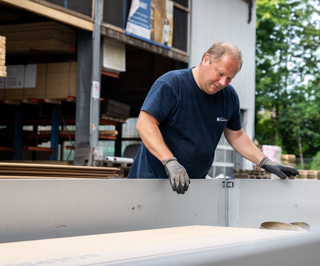 Im Lagerbereich für den Tiefbau sind Holzbalken und Kanthölzer ordentlich gestapelt und für den Abtransport vorbereitet.