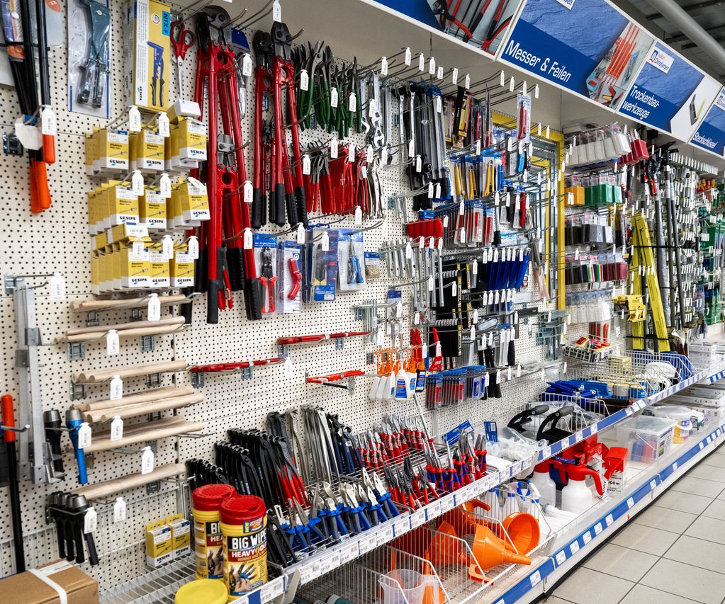 Ein gut sortiertes Regal mit verschiedenen Handwerkzeugen wie Hammer, Zangen und Schraubendrehern im Fachmarkt.