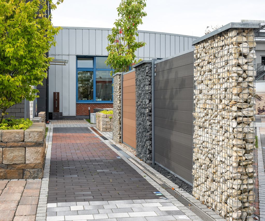 Gepflegter Garten mit blühenden Pflanzen, Rasenfläche und dekorativen Gartenelementen.