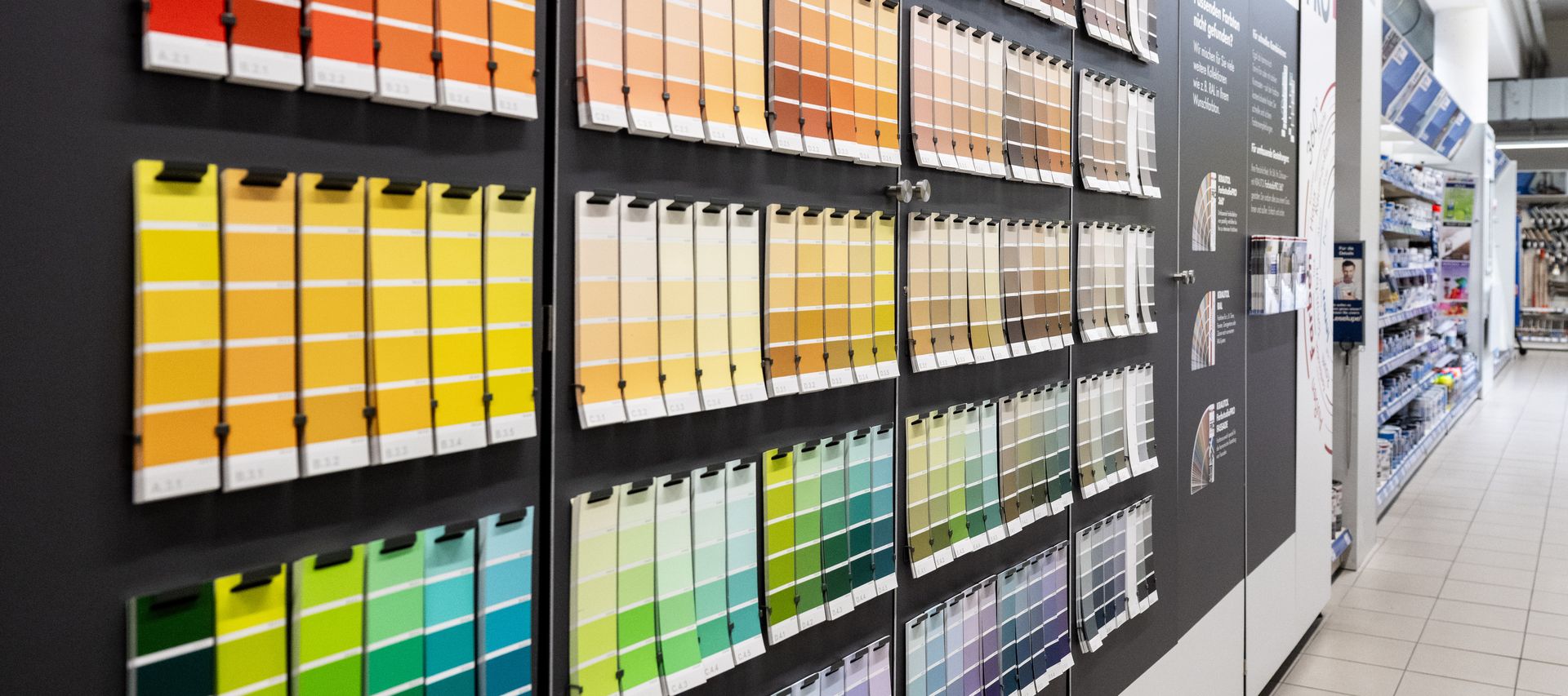 Eine Wand wird mit einer Farbrolle gleichmäßig mit Wandfarbe gestrichen.