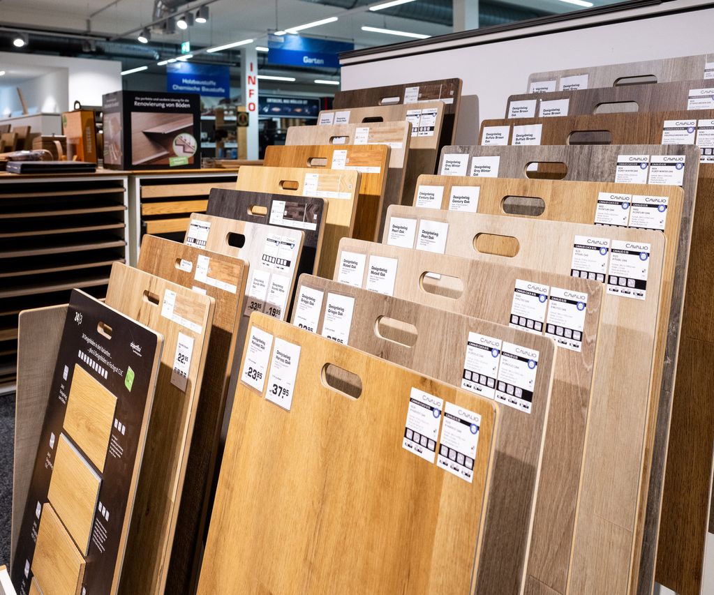 Auswahl verschiedener Bodenbeläge in Holzoptik und Naturtönen auf einem Ausstellungsboden.