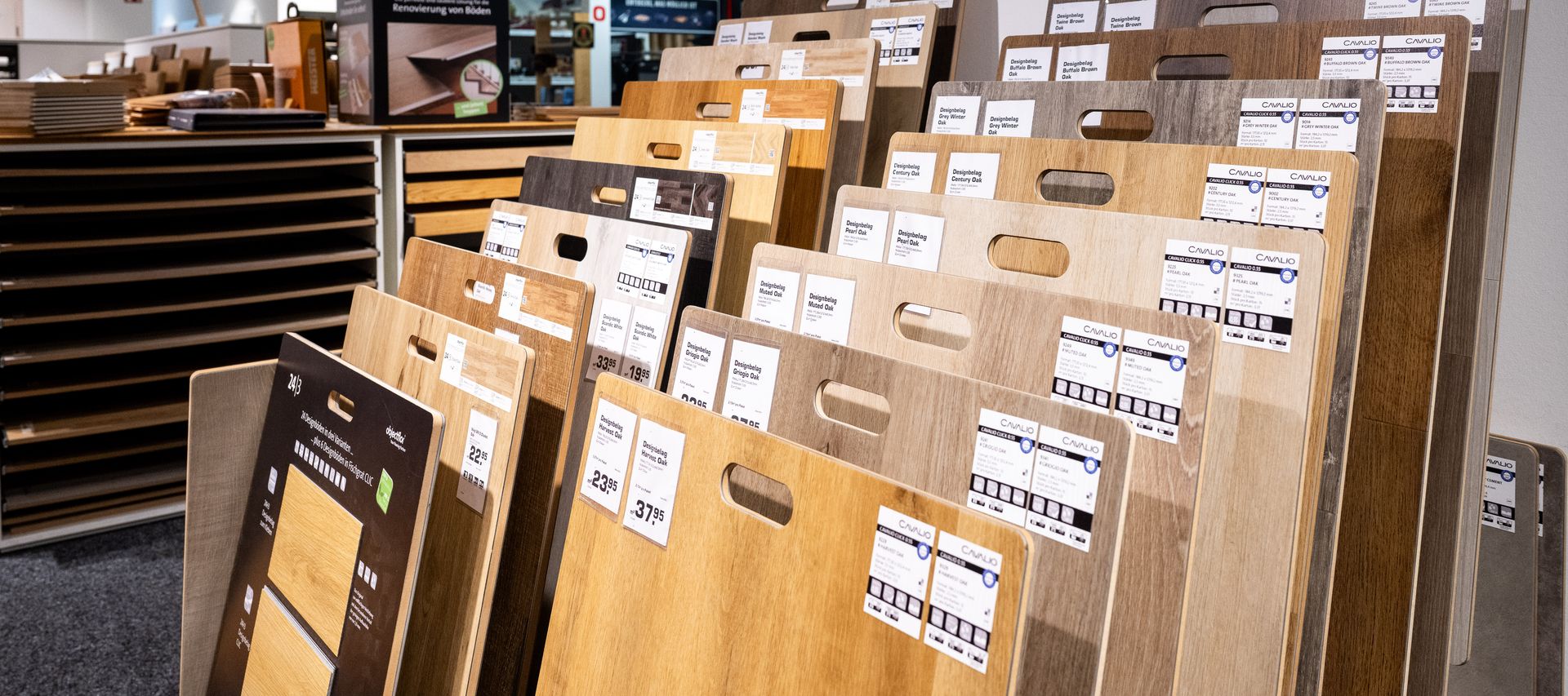 Auswahl verschiedener Bodenbeläge in Holzoptik und Naturtönen auf einem Ausstellungsboden.