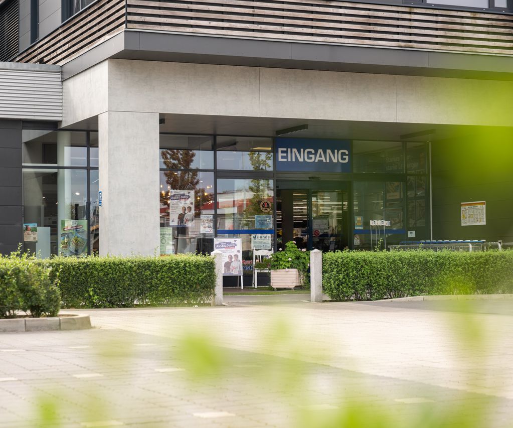 Die Außenansicht mit Eingangsbereich und Beschilderung lädt Kunden zum Besuch des Fachmarkts ein.