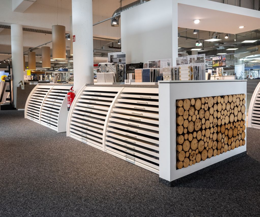 Verschiedene Wandholz-Elemente sind als Musterflächen in der Ausstellung angebracht.