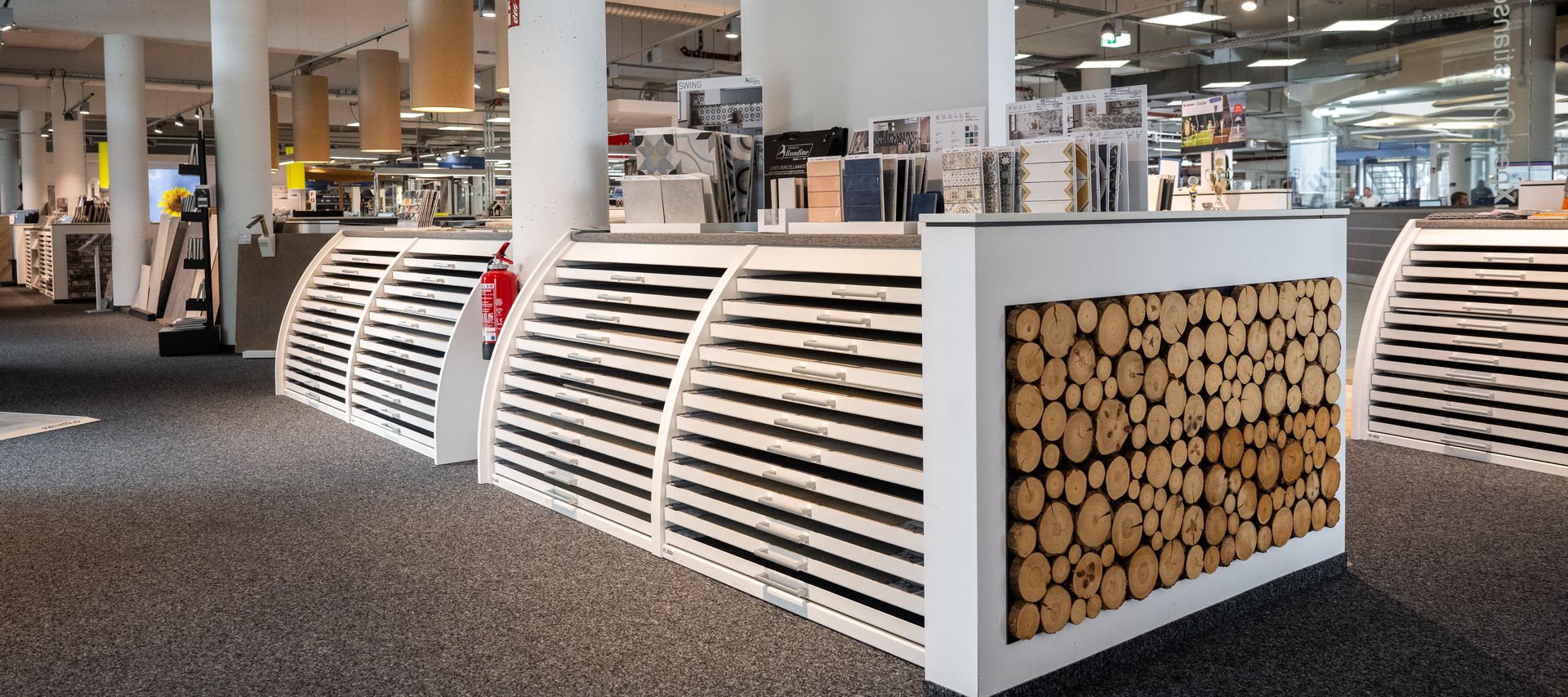 Verschiedene Wandholz-Elemente sind als Musterflächen in der Ausstellung angebracht.