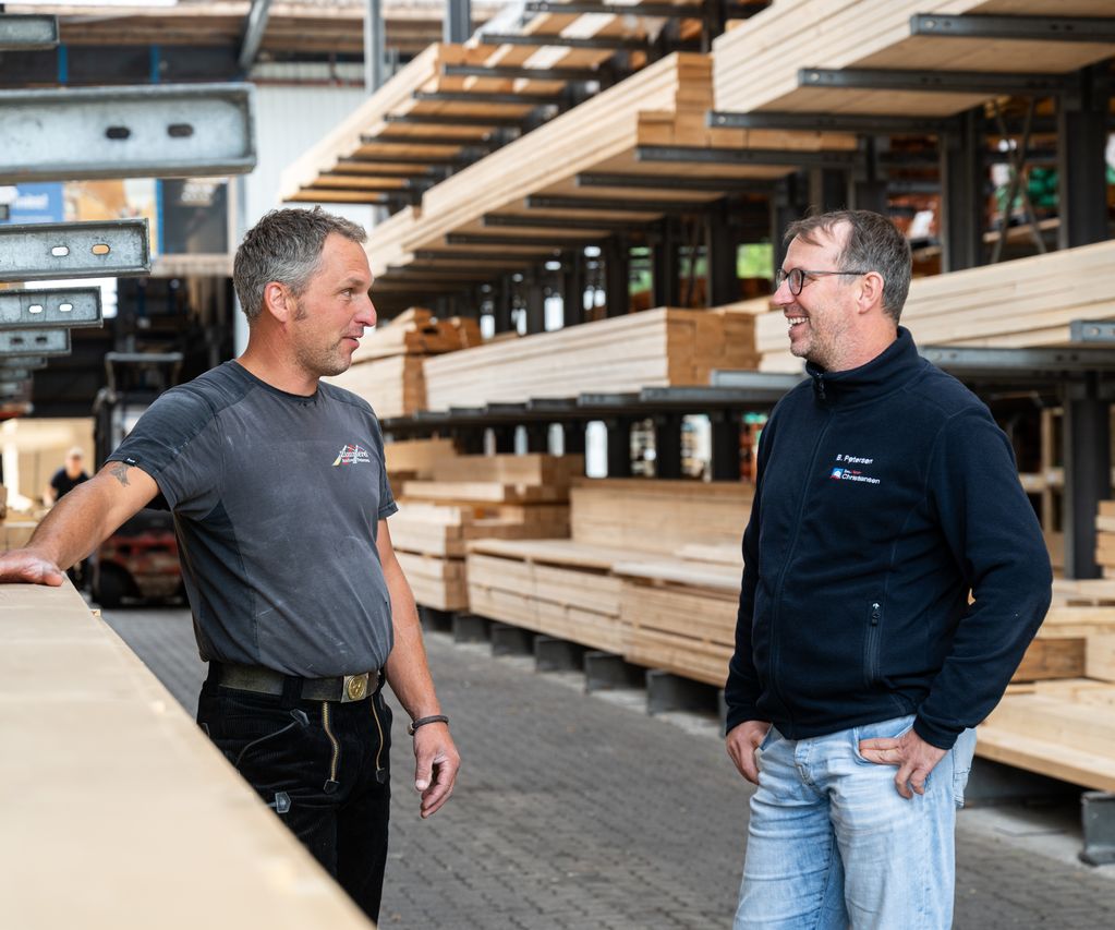 Ein Mitarbeiter berät Vertreter einer Zimmerei zu passenden Holz- und Baustofflösungen im Tiefbaubereich.