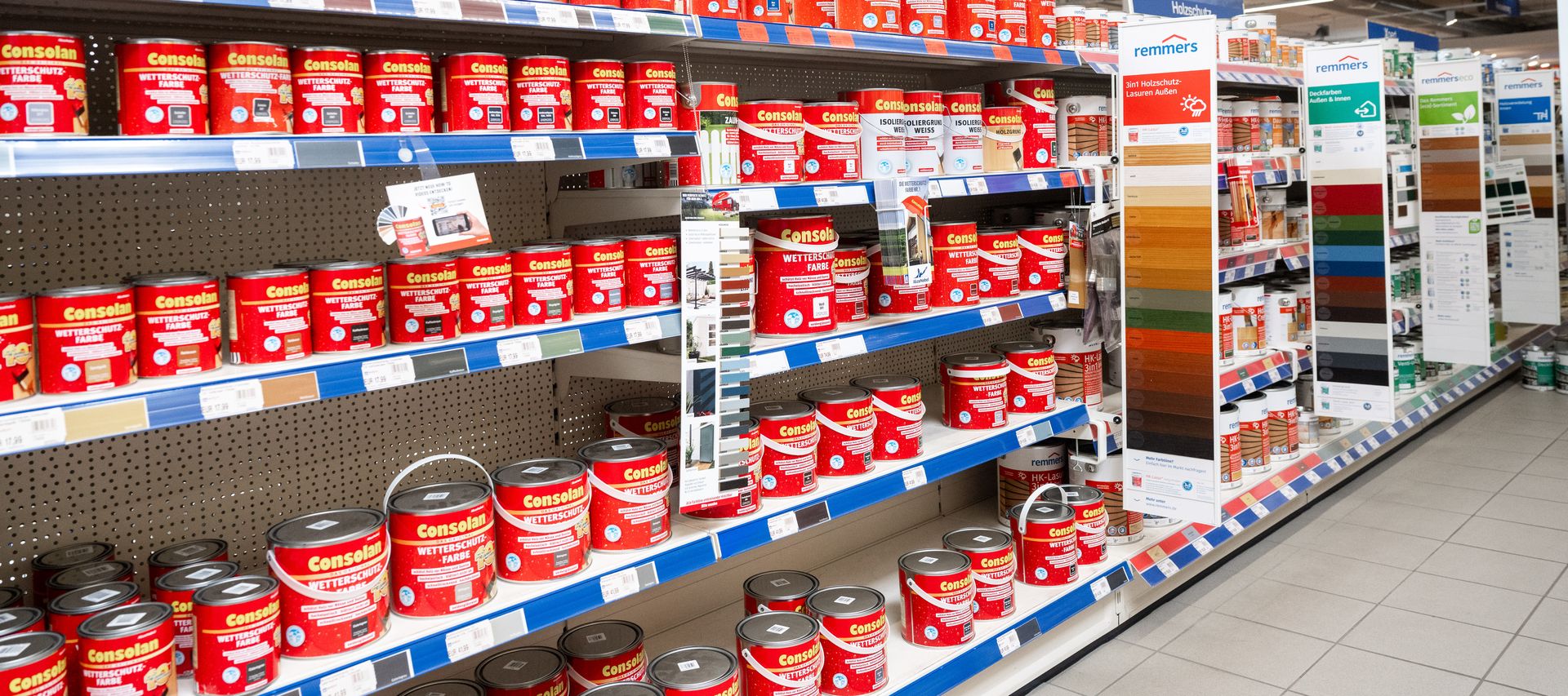 Ein Mitarbeiter erklärt einem Kunden die Unterschiede zwischen Holzlasur, Holzöl und Holzfarbe.