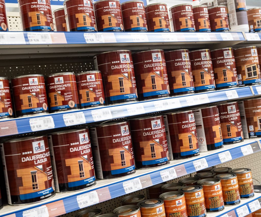 Regale mit verschiedenen Holzschutz- und Farbprodukten wie Lasuren, Ölen und Lacken im Fachmarkt.