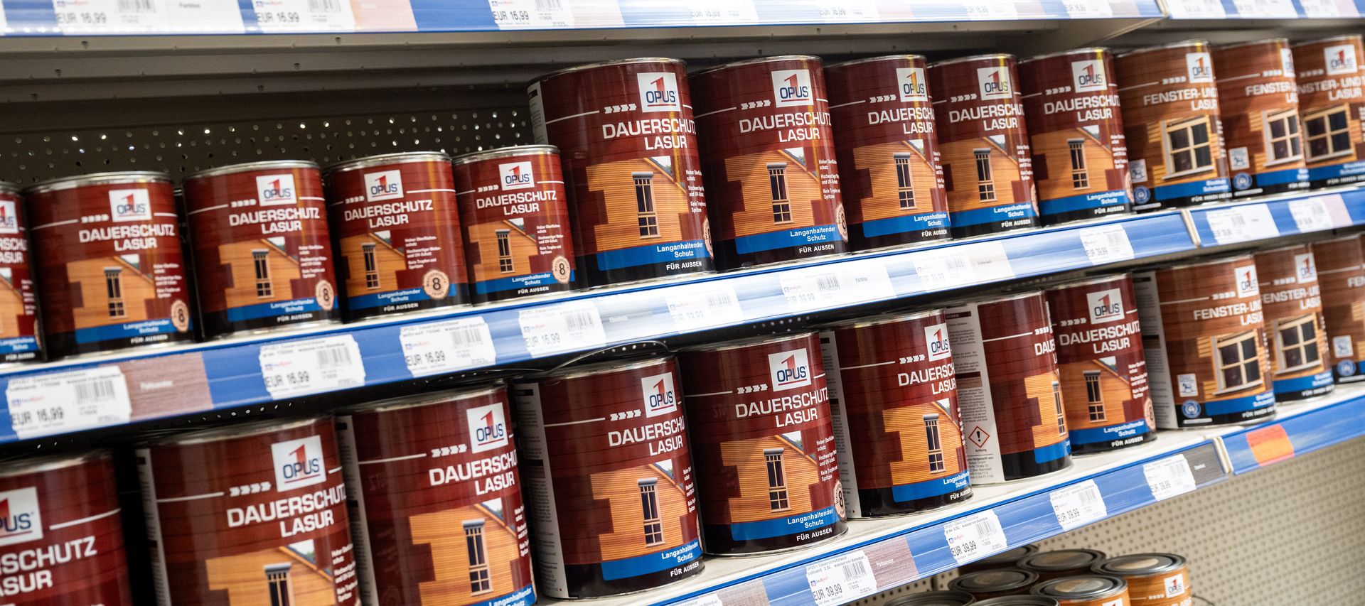 Regale mit verschiedenen Holzschutz- und Farbprodukten wie Lasuren, Ölen und Lacken im Fachmarkt.
