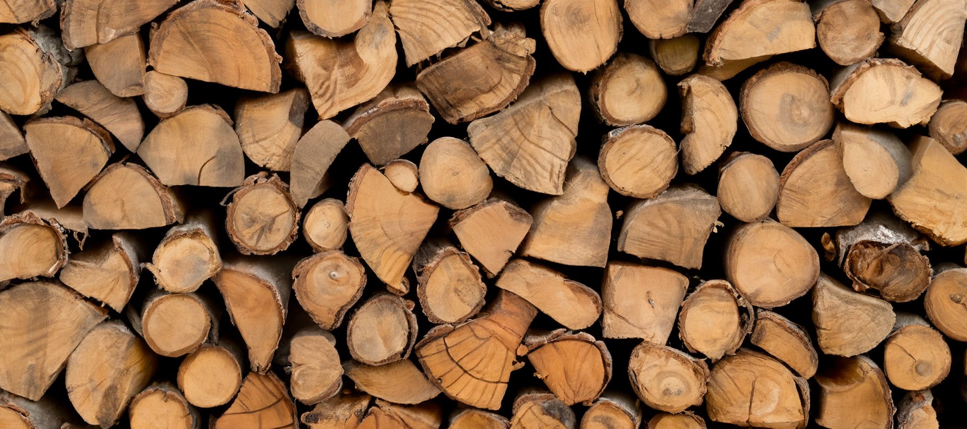 Gespaltenes Kaminholz ist ordentlich aufgeschichtet und bereit für den Einsatz im Ofen.