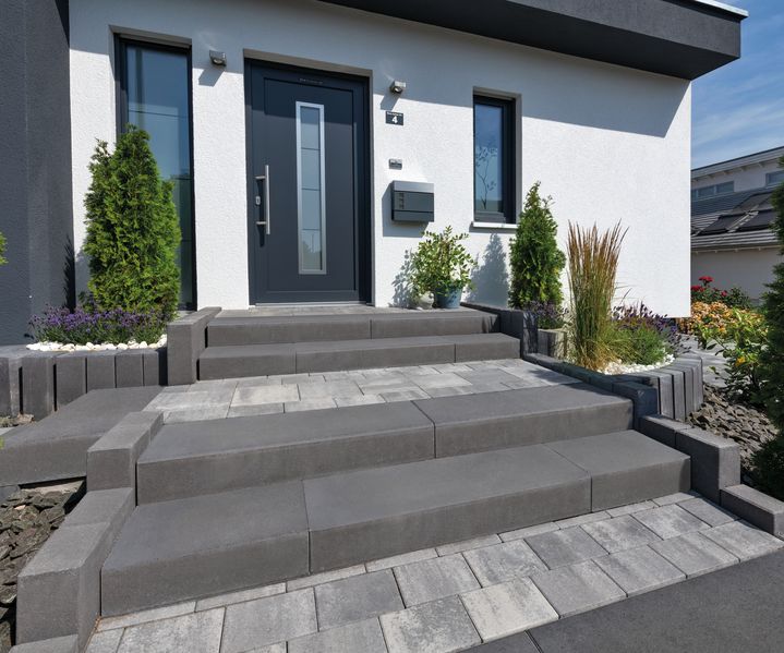 Senkrecht gesetzte Beton-Palisaden zur Beeteinfassung und leichten Hangabstützung im Garten.