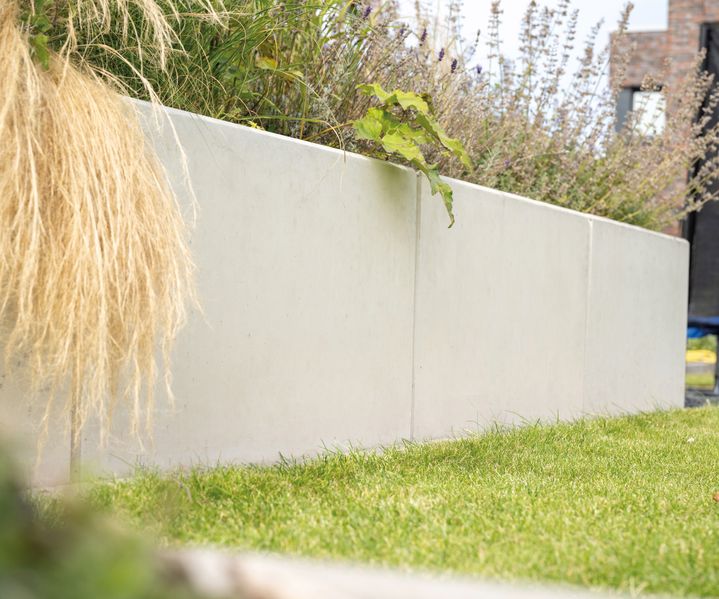 L-Steine sind als Stützelemente gesetzt und sichern eine Höhenkante im Außenbereich.