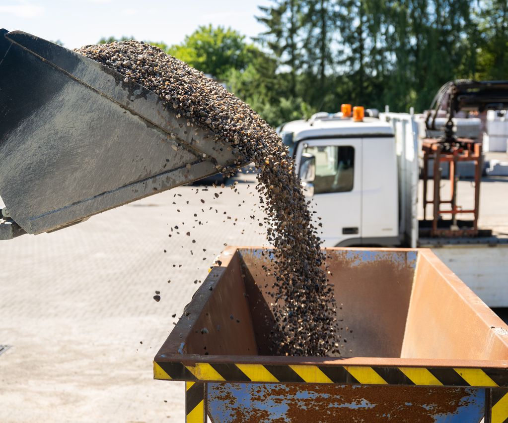 Kies ist als lose Schüttung auf einer Fläche verteilt und eignet sich für Wege, Einfahrten oder Beete.