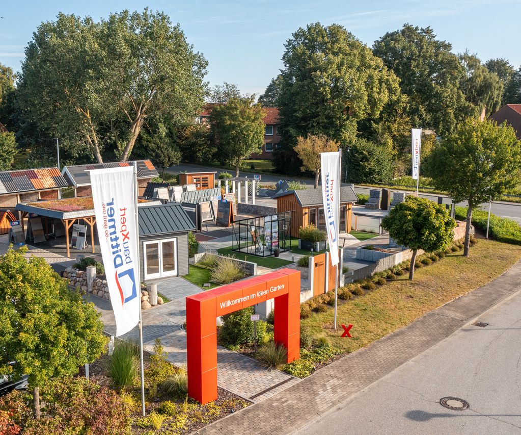 Luftaufnahme des Ideen-Gartens bei bauXpert Dittmer mit Musterhäusern, Ausstellungsflächen und Eingangstor mit rotem Bogen