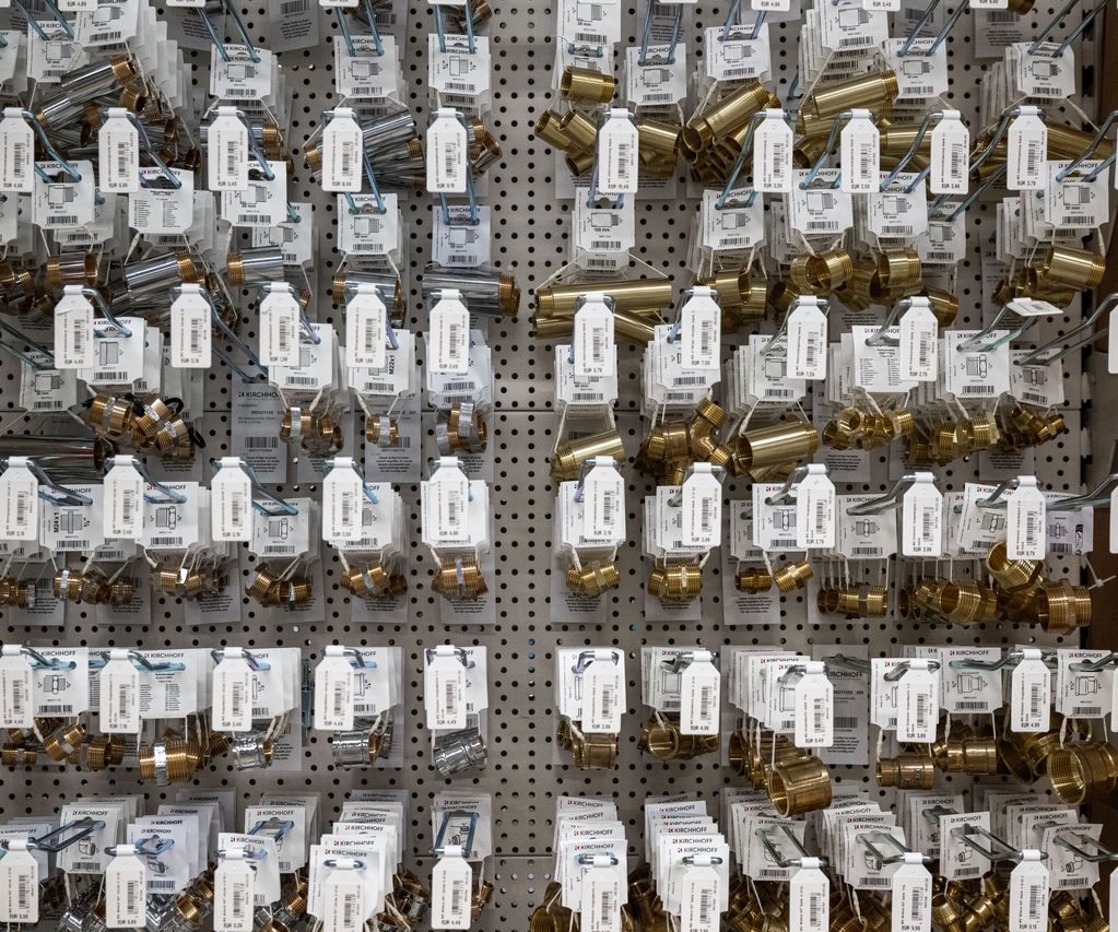 Nahaufnahme eines Verkaufsregals bei bauXpert Dittmer mit verschiedenen Messingfittings und Übergangsstücken für die Sanitärinstallation