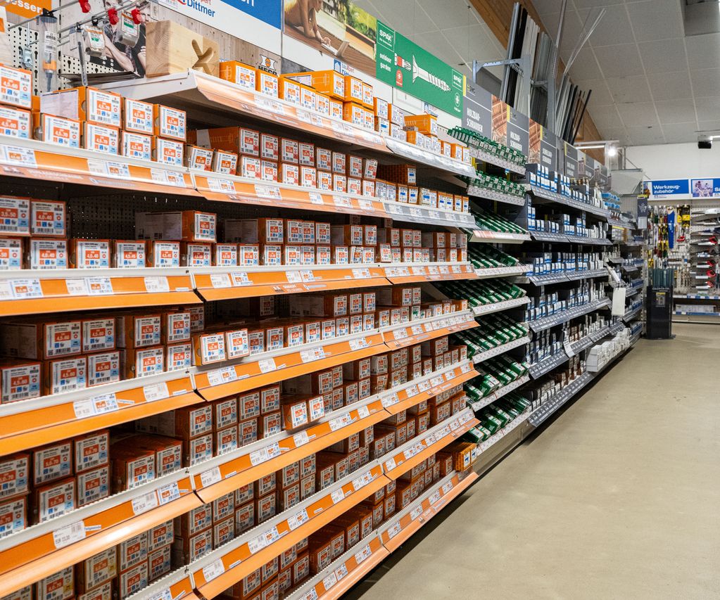 Gang im Fachmarkt von bauXpert Dittmer mit Regalen voller Schrauben, Dübel und Befestigungstechnik
