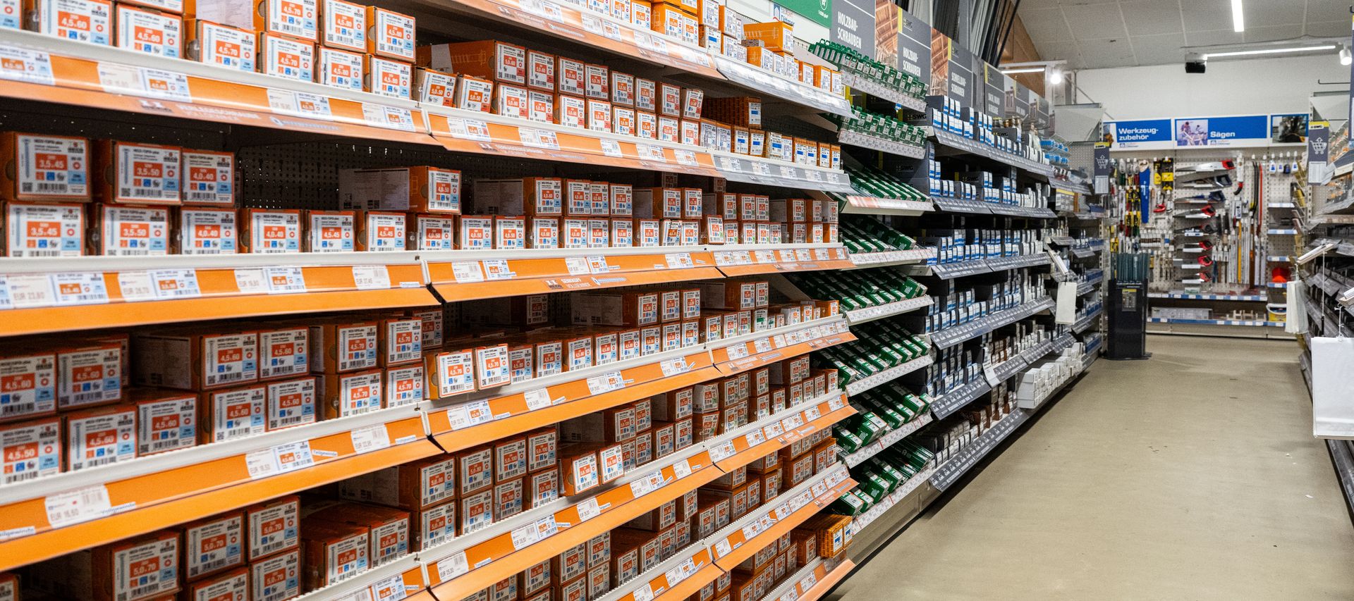 Gang im Fachmarkt von bauXpert Dittmer mit Regalen voller Schrauben, Dübel und Befestigungstechnik