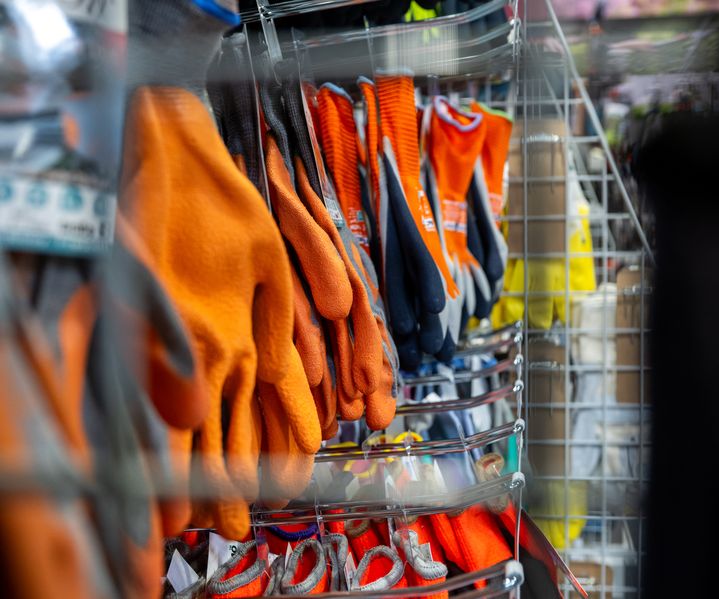 Nahaufnahme von orangefarbenen Arbeitshandschuhen im Fachmarkt von bauXpert Dittmer in Lütjenburg.