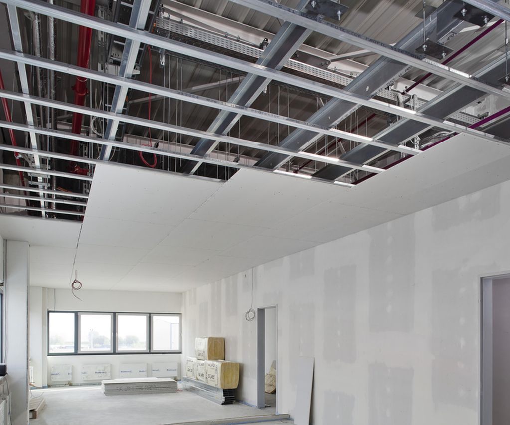 Trockenbauprofile werden in einem halbfertigen raum gezeigt die Decke ist nur zur hälfte it Gipskartonplatten bestückt die Trockenbauprofile bilden die Unterkonstruktion